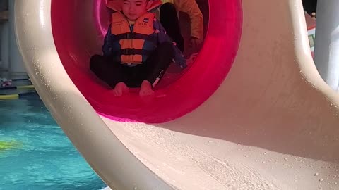 A baby sliding in a water park.