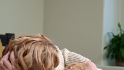 A Woman Cuddling Her Cat On The Bed