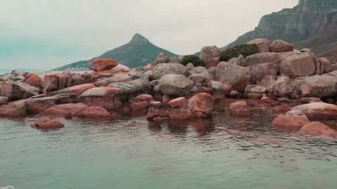 Boulders of rock lying along the coastline of the sea in cape town south africa