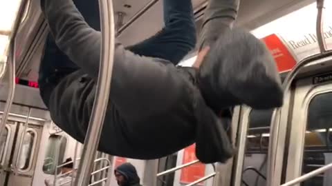 Man in grey sweater hanging upside down