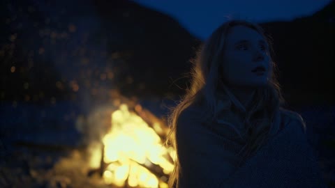 A Woman Backlit by the Bonfire