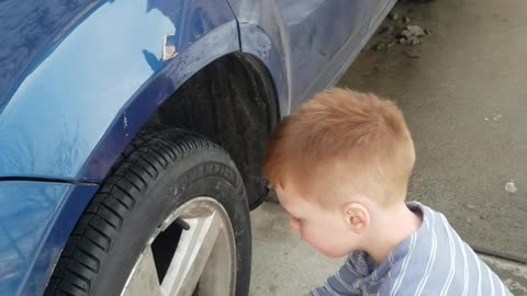 Boy explains how every work day starts. While trying to fix daddy's car