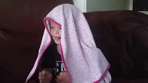 Funny baby can't get blanket straight whilst watching Trolls