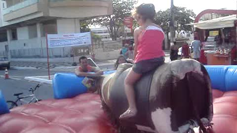 Child climbs on wild bull