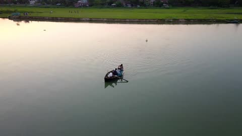 People In A Rowboat Across The River