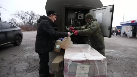 Military personnel distributing water to residents of Volnovakha