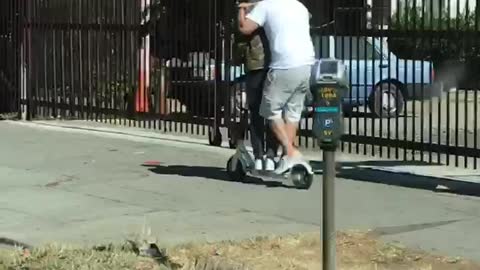 Two guys riding scooter together caps