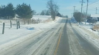 Driving down snowy county road