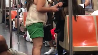 Girl brushing other girls hair on subway