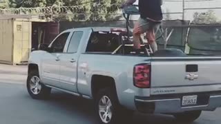 A man on a treadmill on the back of a silver truck
