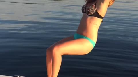 Girl tries to backflip off of boat into water but lands on her back