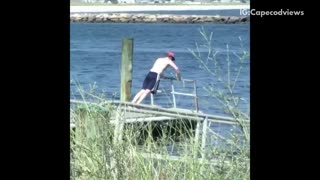 Guy red hat shirtless working out on pier dock water