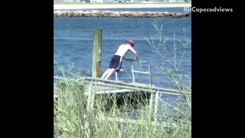 Guy red hat shirtless working out on pier dock water