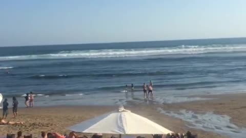 Two guys on sand beach fighting