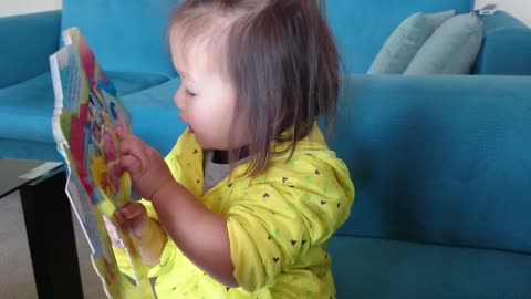 Toddler reads English book in native tongue