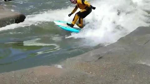 Guy yellow suit river surfing