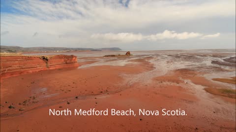 Red sand, blue skies, and white clouds
