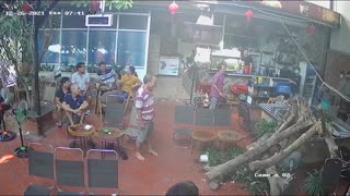 Man Drinking Coffee Dodges Falling Tree in Restaurant