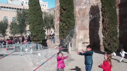 children play with soap bubbles)