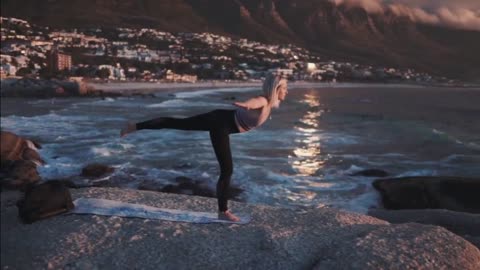 The beauty of yoga on the sea rocks with sunset