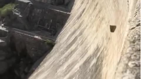 dropping stone from the top of a dam