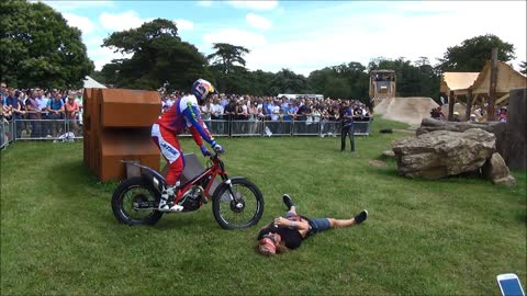Motorcycle trials rider stunts over brave volunteer