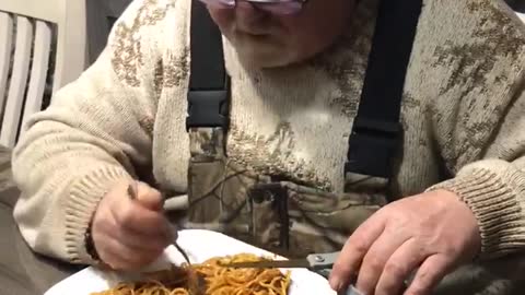 Man uses scissors to make eating spaghetti easier