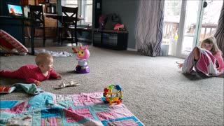 Happy baby laughs at silly big sister