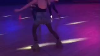 Blonde girl falls at roller skating rink pink