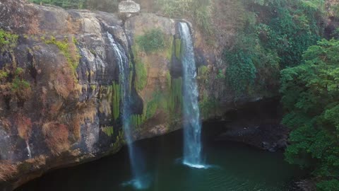 Water falls off a rocky mountain cliff