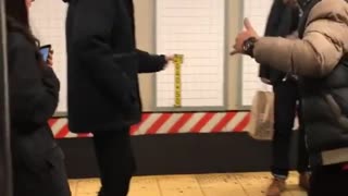 Two men dancing salsa on subway platform