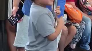 Little boy grey shirt licking subway pole train