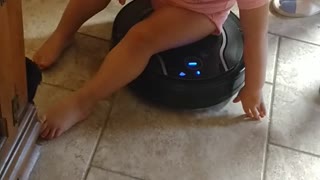 Baby riding the robot vacuum