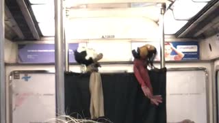 Puppet show on subway ride, two puppets in red and white shirt sing together