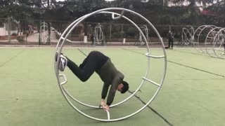 Green jacket guy in metal wheel rolls and hits head on concrete