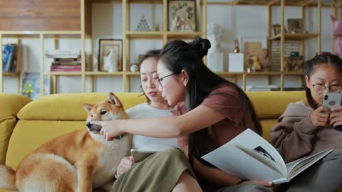 Sisters Playing With Their Dog