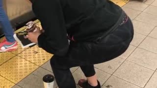 Girl frozen squatting in front of coffee in front of subway