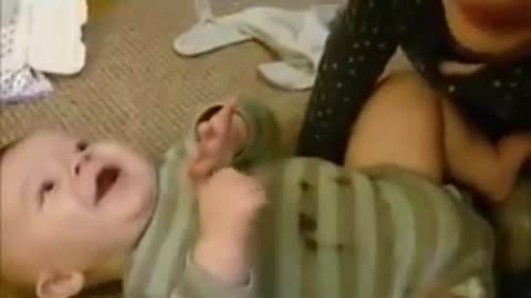 Girl blowing raspberries on her baby brother