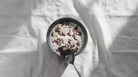 A serving of alphabet beans on a bowl of milk