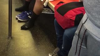 Guy backpack white shorts blue shirt stretching left and right subway orange seats