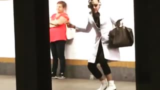 Guy white long coat dancing subway platform headphones