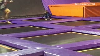 Little kid falls off of orange box at trampoline park and falls on floor