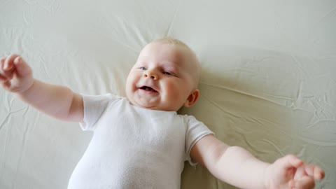 a small child giggling on the bed