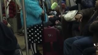 Guy on subway wears blue fur coat and white polka dot shorts