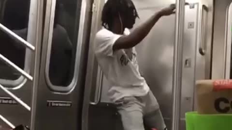 Man on subway train dances by himself in the corner