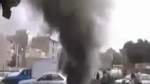 Black smoke coming out of a hole in a road in Tehran