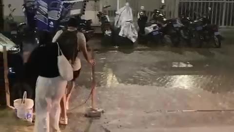 Woman Trips on Curb in Heavy Rain