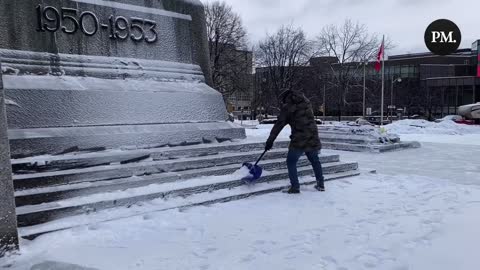 Truckers shoveling snow around historic monuments in Ottawa