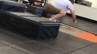 Balding guy in gym practicing how to stand up on surfboard