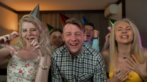 Excited young people partying with party hats